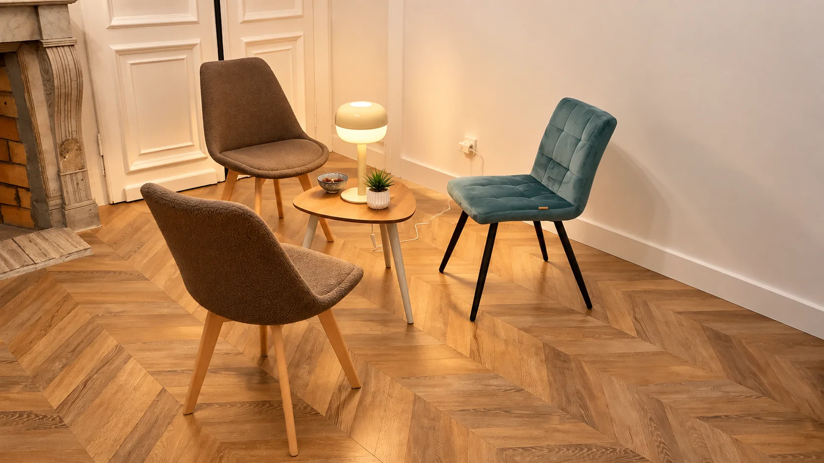 Espace de consultation chaleureux avec fauteuils, cheminée en marbre et parquet en bois.